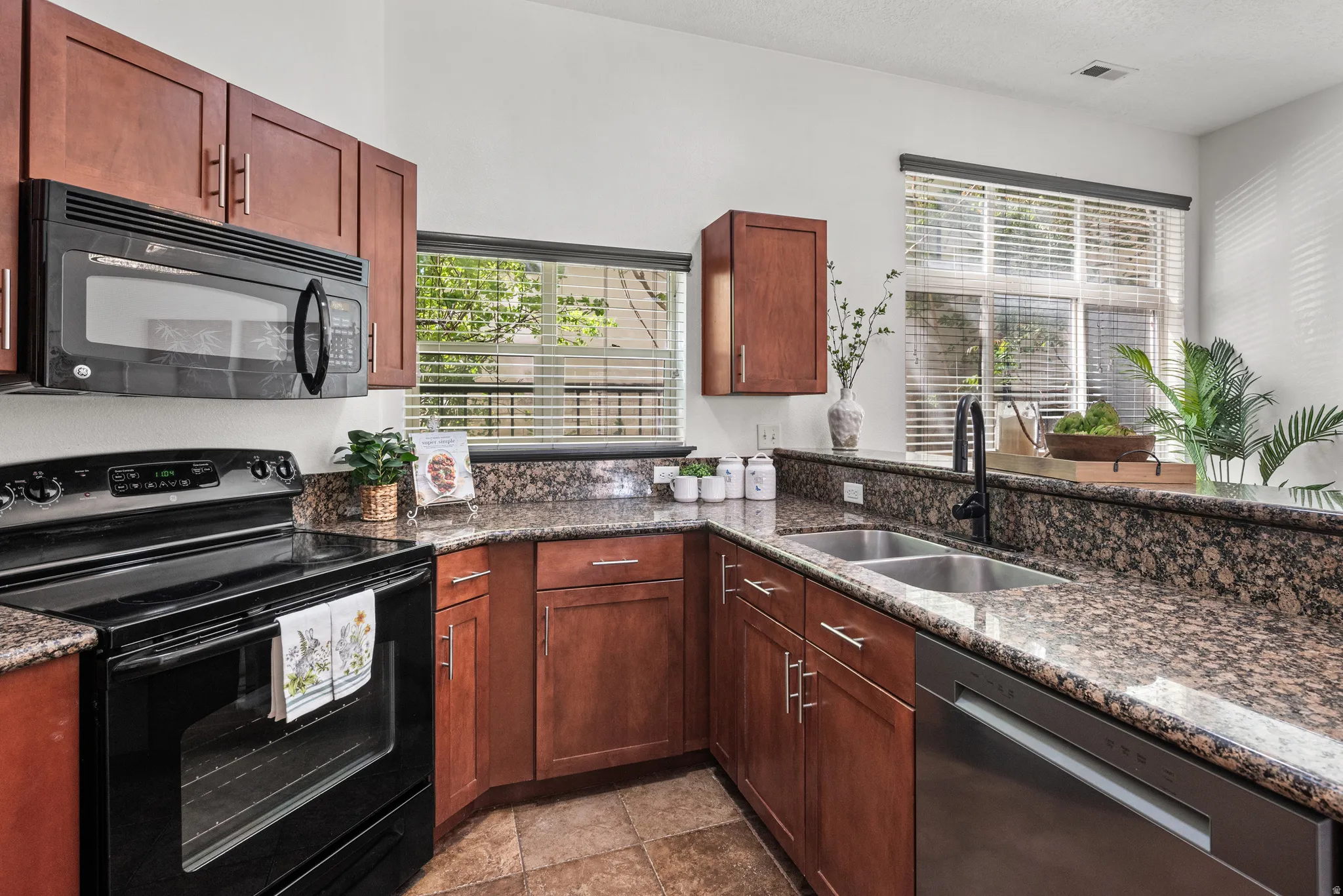 Kitchen featuring black appliances and dark stone counters