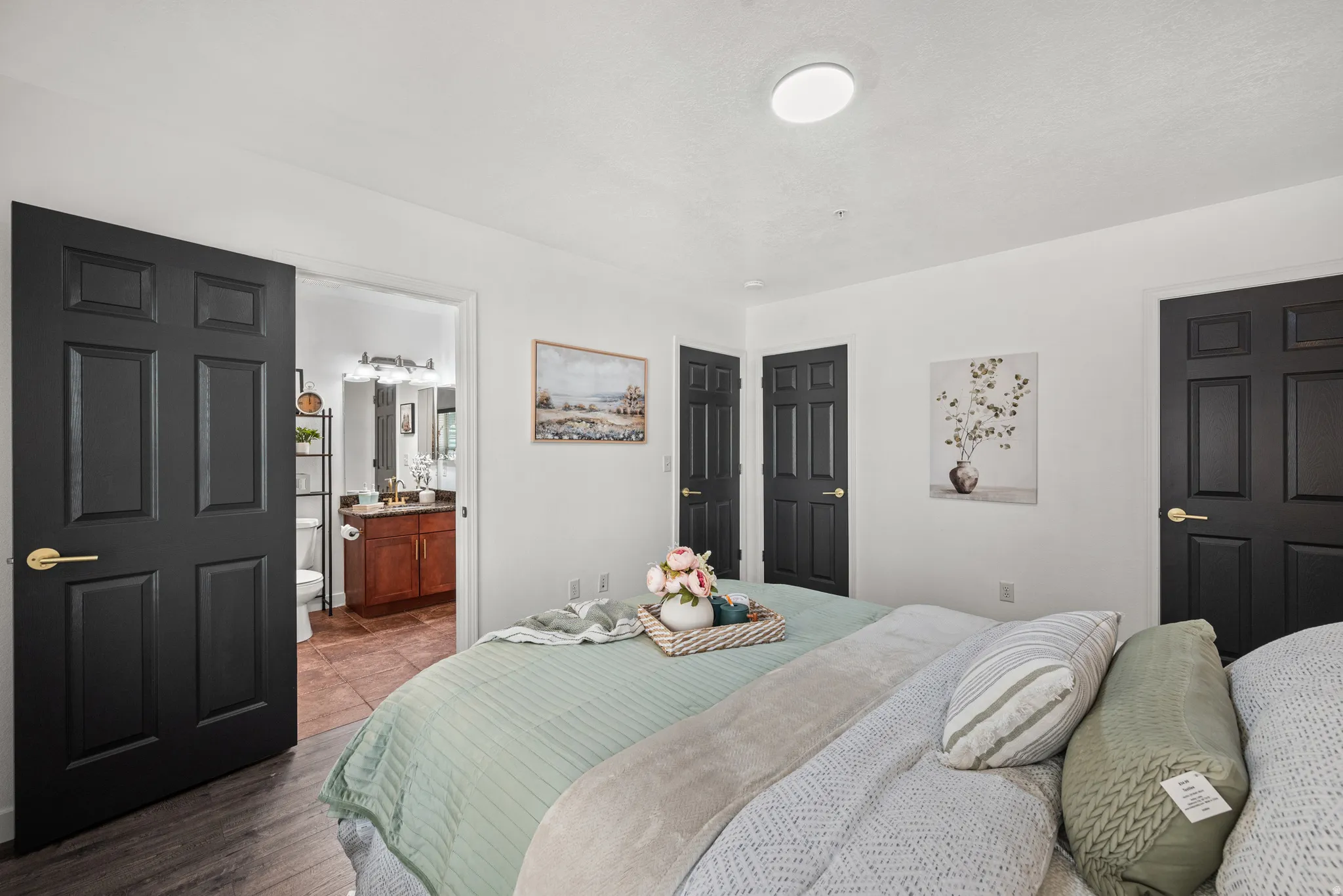 Bedroom featuring wood finished floors and connected bathroom