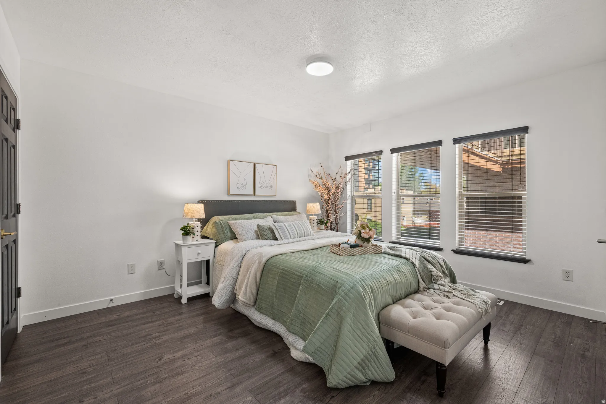 Bedroom with a textured ceiling and dark wood-type flooring