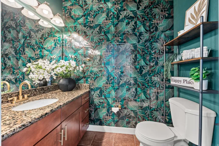 Half bath with wallpapered walls and vanity