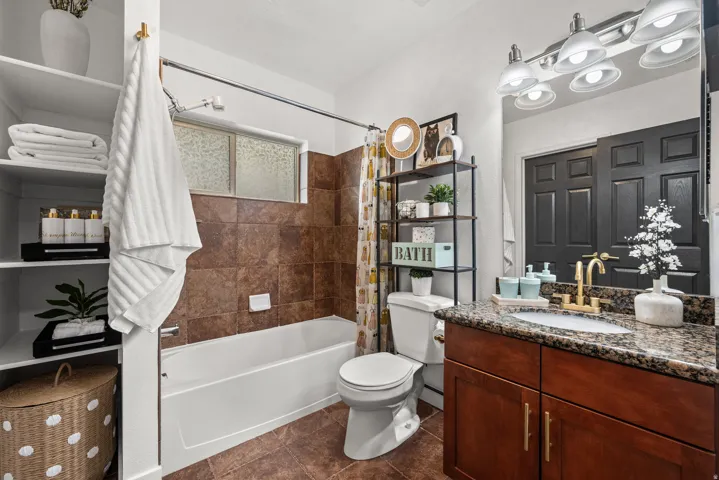 Full bath featuring vanity and shower / bathtub combination with curtain