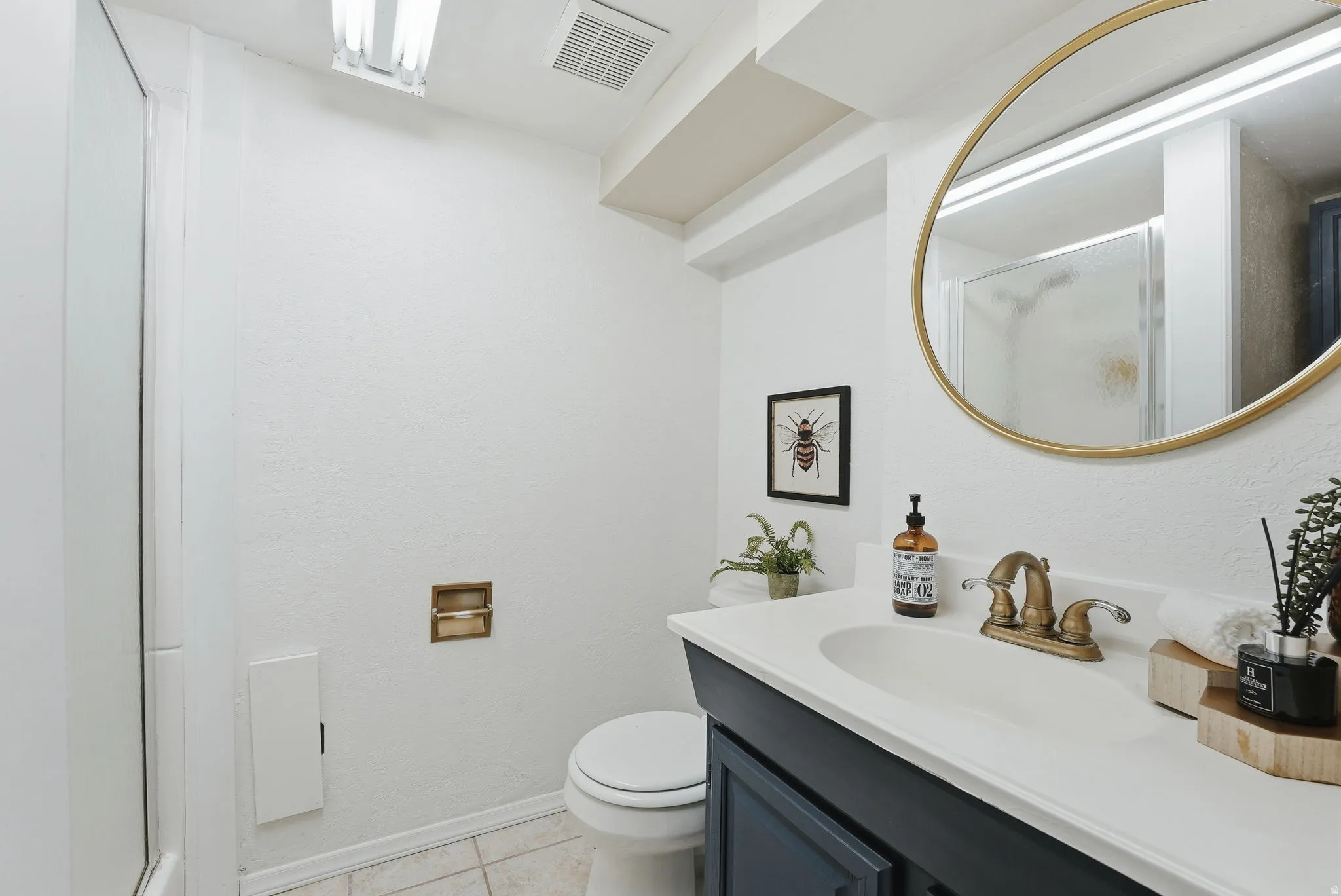 Bathroom featuring a shower stall, vanity, and light tile patterned flooring
