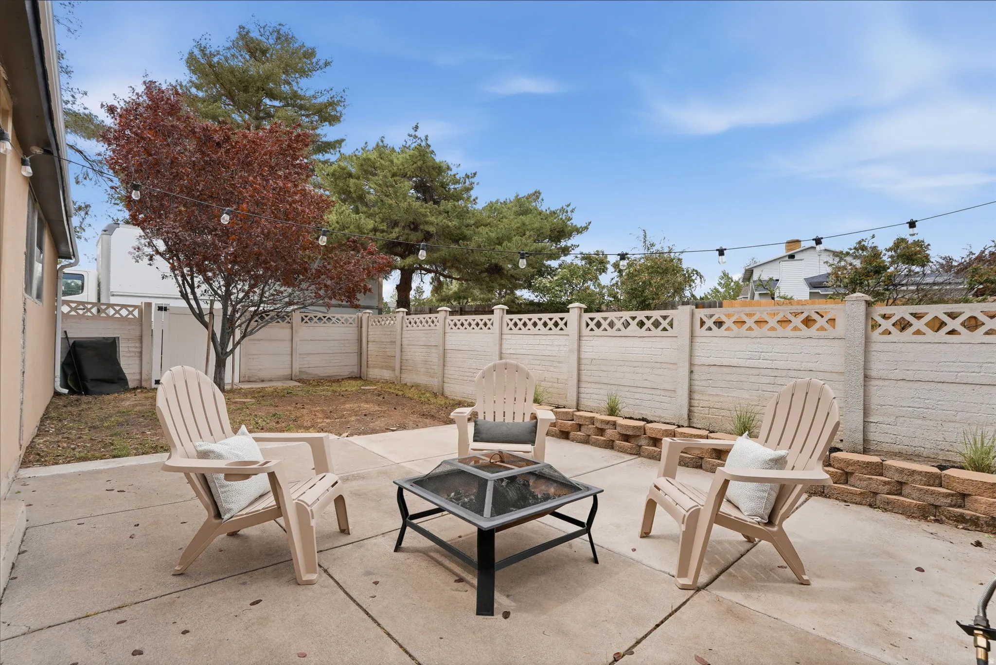 Fenced backyard with a patio and a fire pit