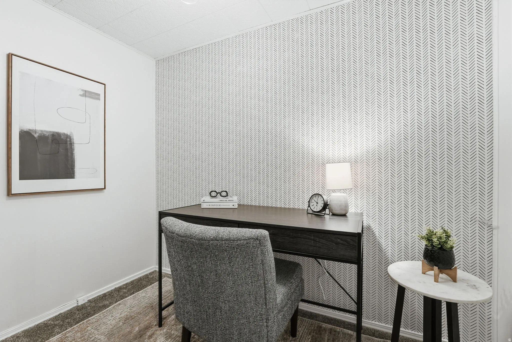 Carpeted office featuring wallpapered walls and an accent wall