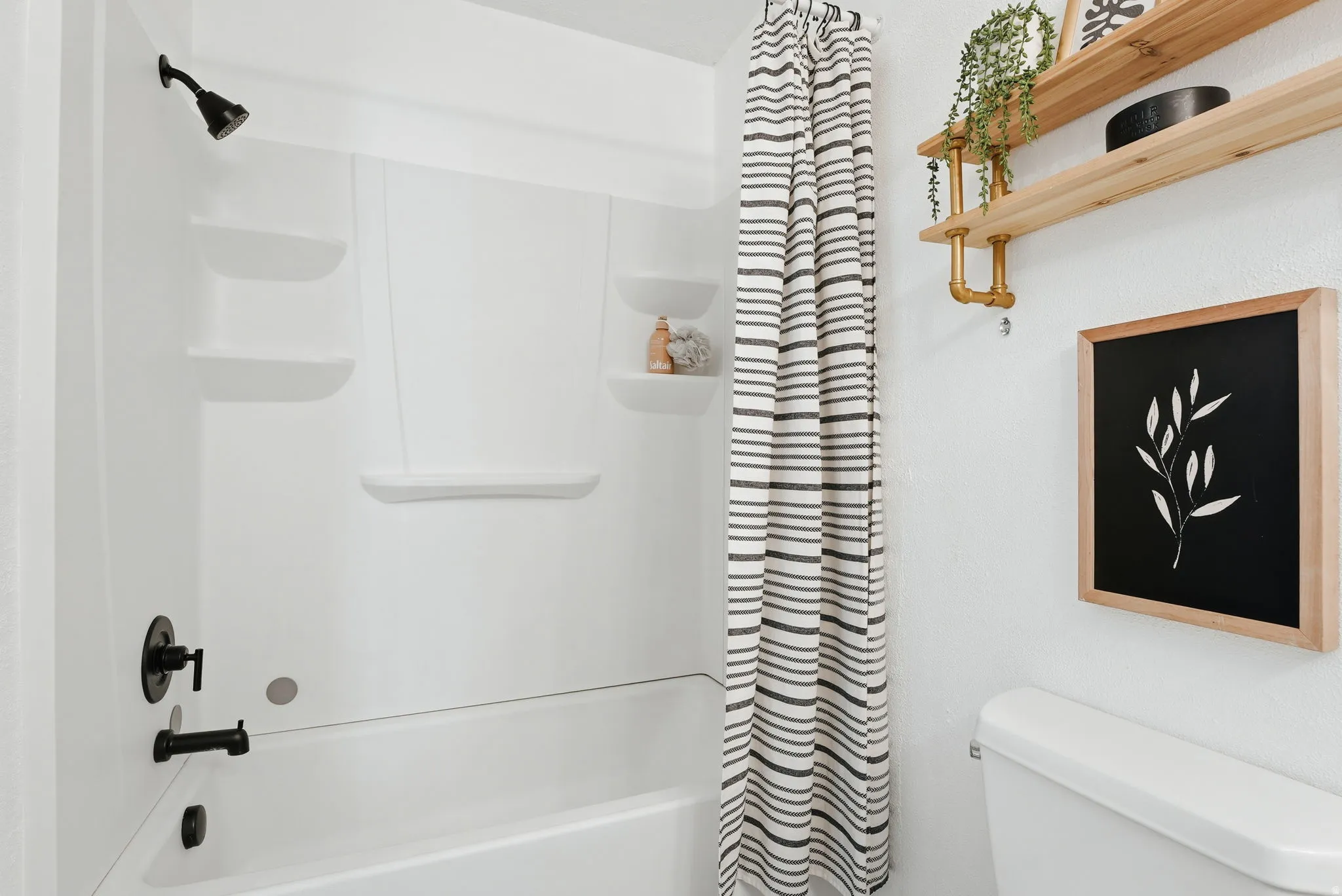 Bathroom featuring toilet and shower / bathtub combination with curtain
