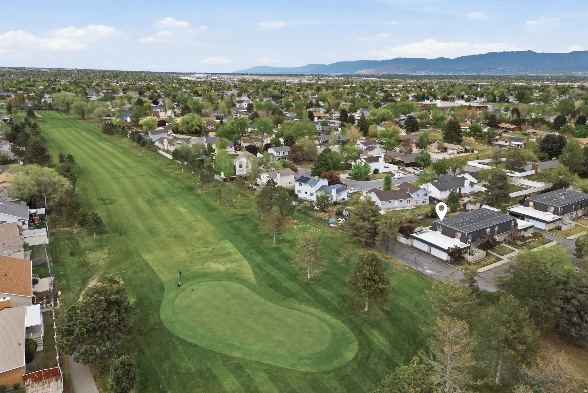 Aerial view of residential area with mountains and a golf course