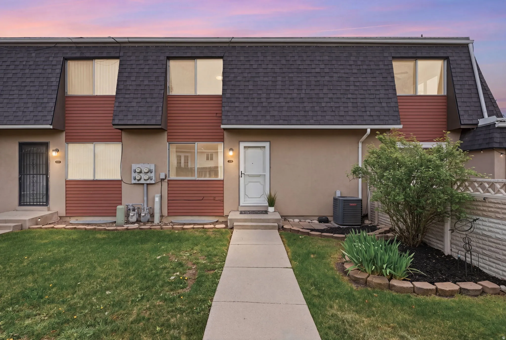 Contemporary home with a shingled roof, a yard, and stucco siding