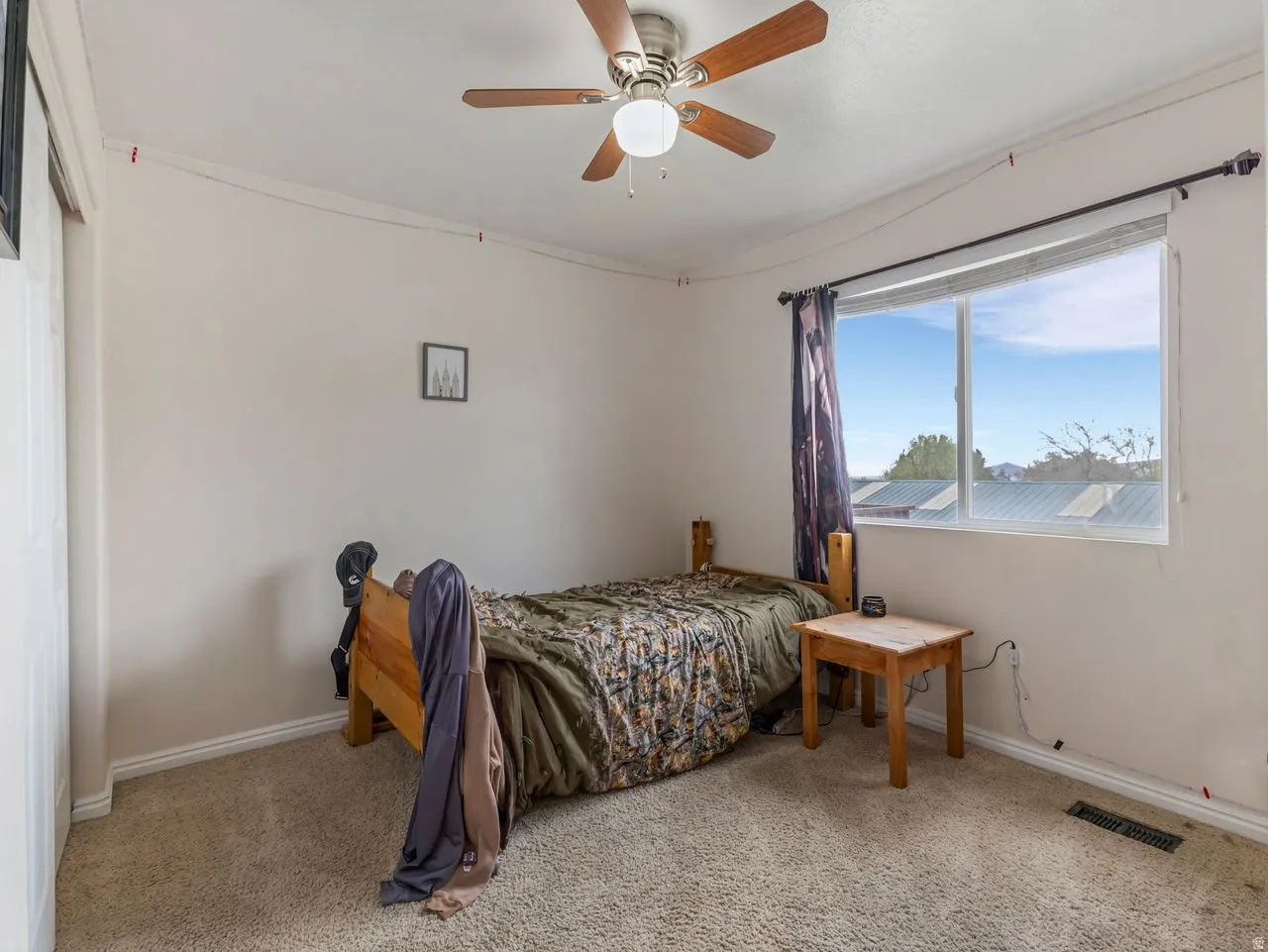 Bedroom with a ceiling fan and light carpet