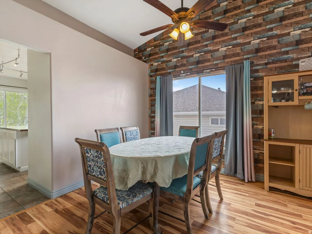 Dining area featuring vaulted ceiling, wood finished floors, ceiling fan, and healthy amount of natural light