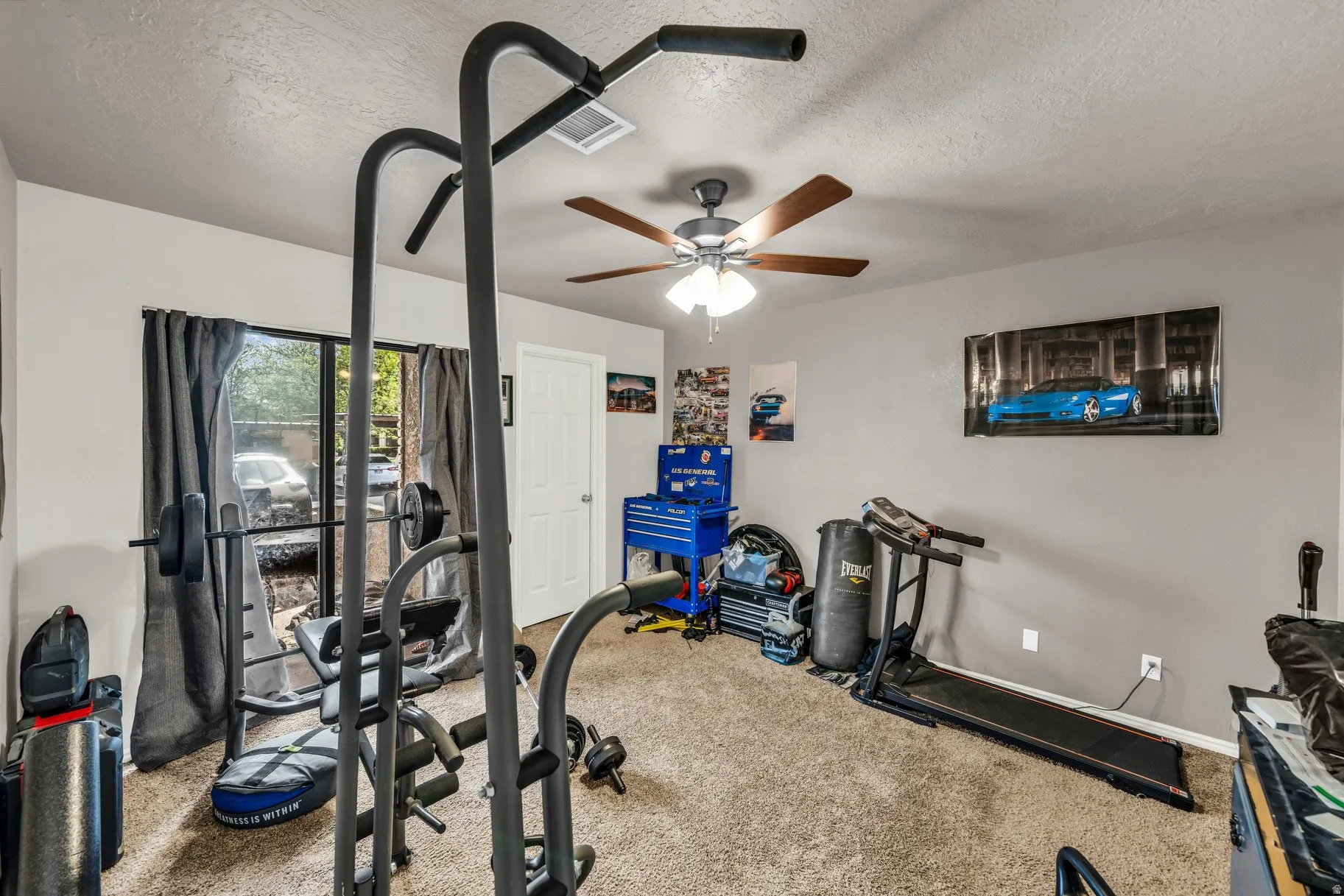 Workout area with carpet flooring and a textured ceiling