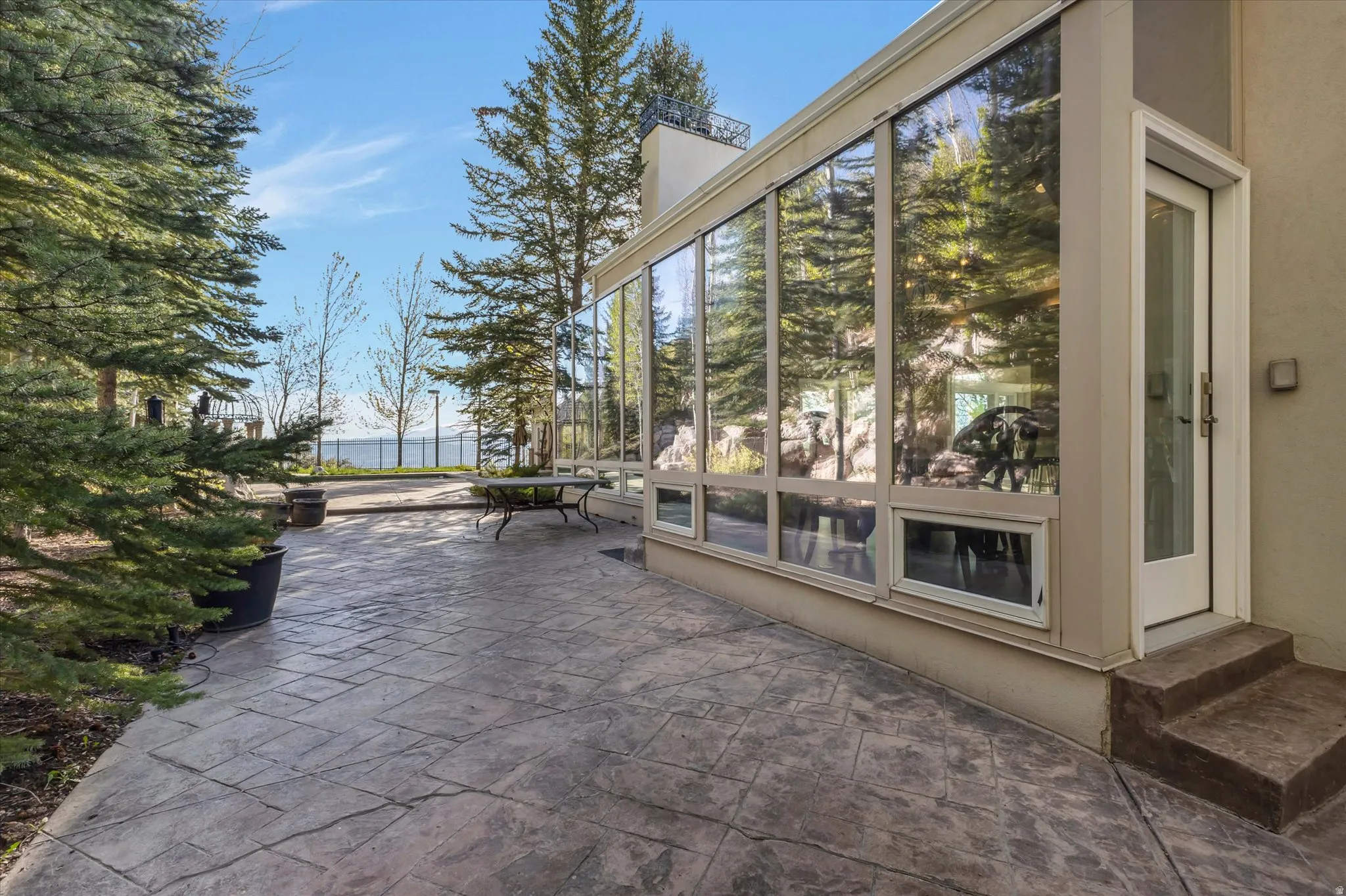View of patio with a sunroom and entry steps