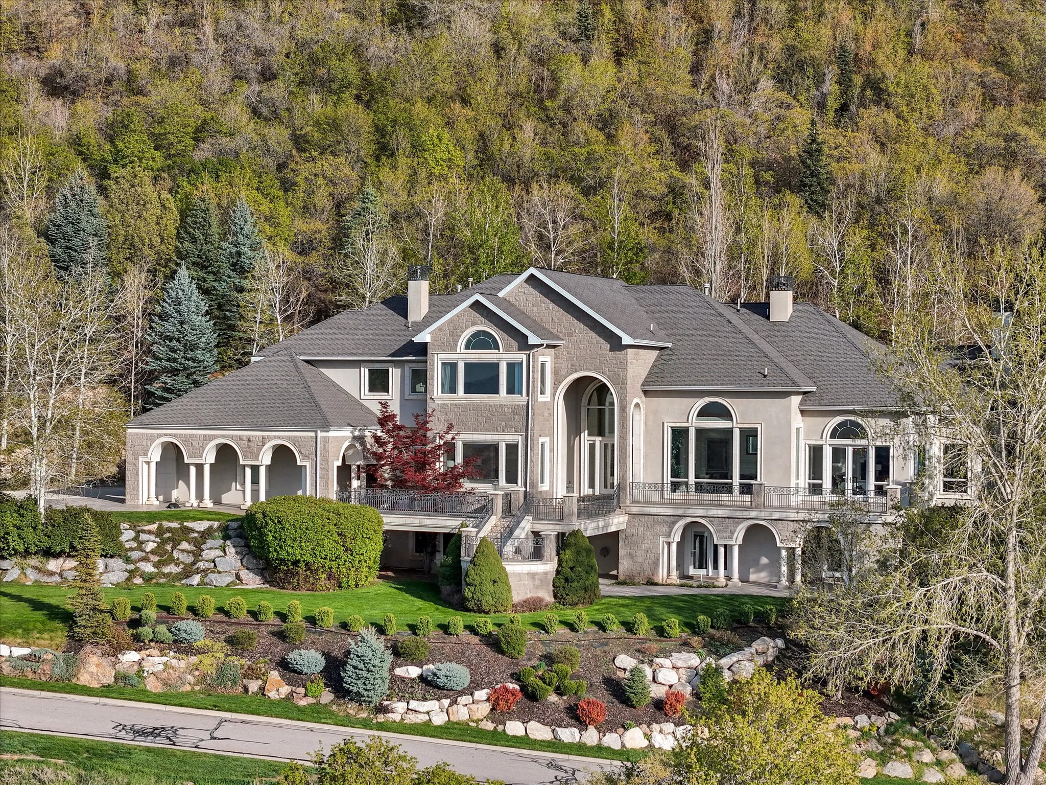 View of front facade featuring a chimney, a shingled roof, and stucco siding