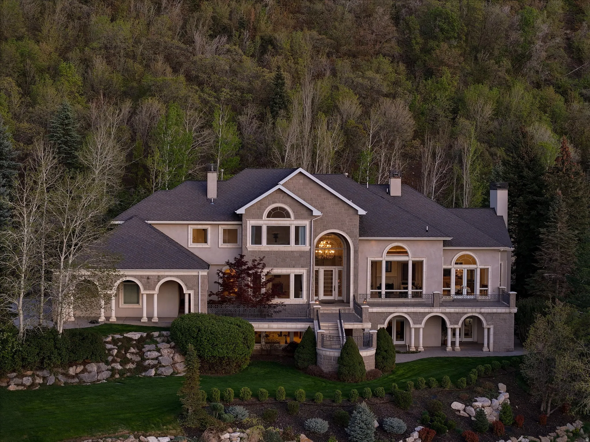 View of front of property featuring a chimney, stucco siding, a front lawn, and a shingled roof