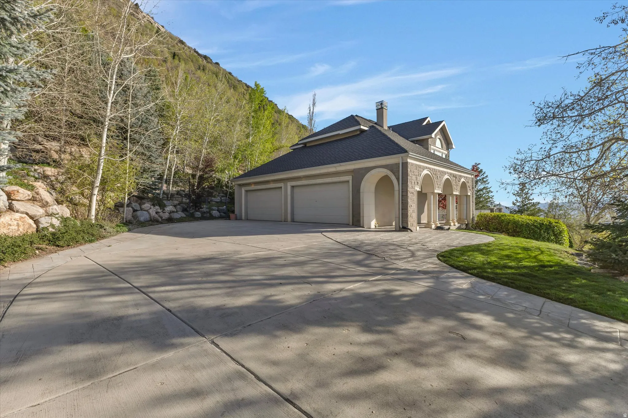 View of property exterior featuring a chimney, driveway, a yard, and a garage