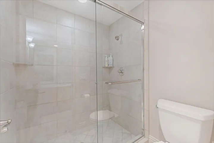 Full bathroom featuring toilet and a stall shower