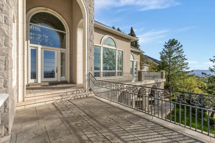 Entrance to property featuring stucco siding, a mountain view, and stone siding