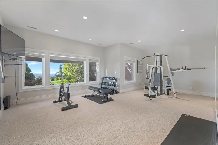Workout area featuring light colored carpet and recessed lighting