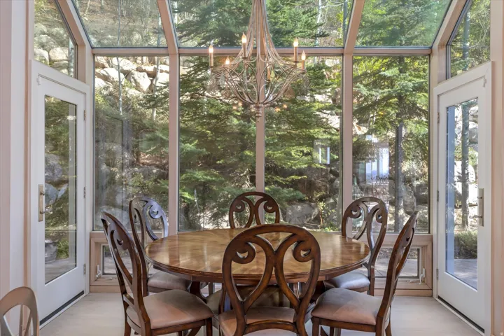 Sunroom with healthy amount of natural light and suspended lighting