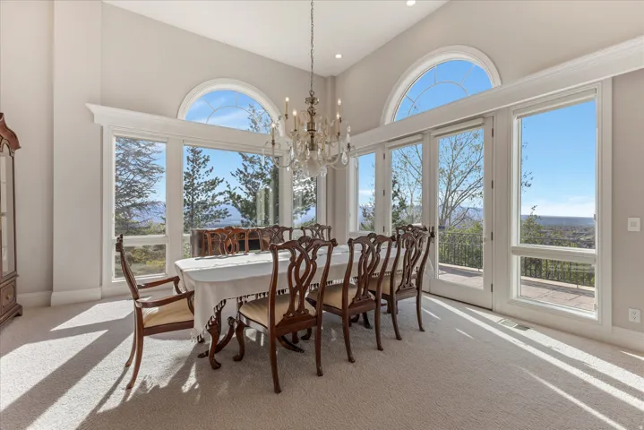 Dining room with a chandelier, light carpet, and a high ceiling