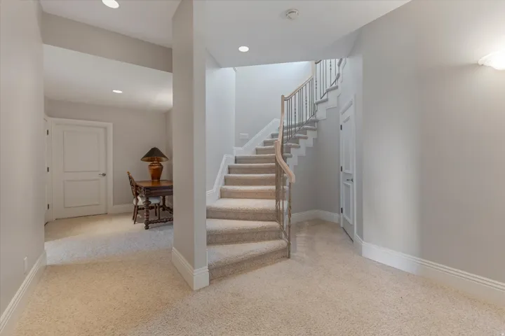 Stairway with carpet floors and recessed lighting