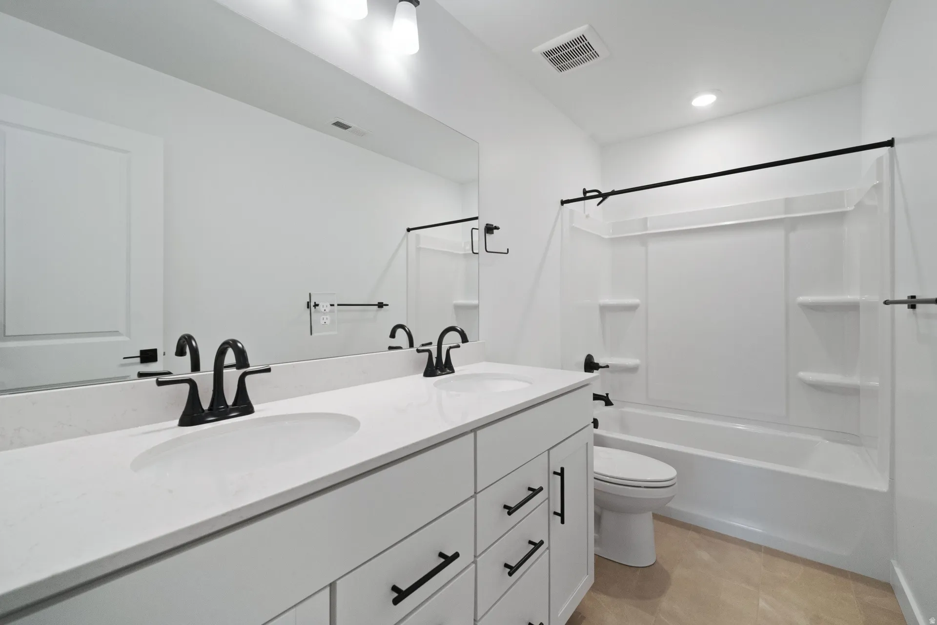 Full bath with double vanity and shower / bath combination