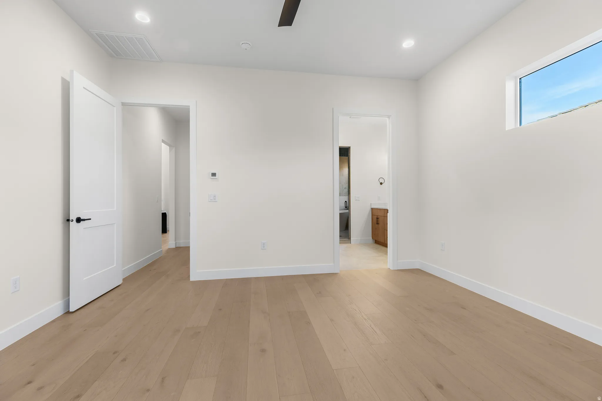 Unfurnished bedroom with light wood finished floors, ensuite bath, ceiling fan, and recessed lighting