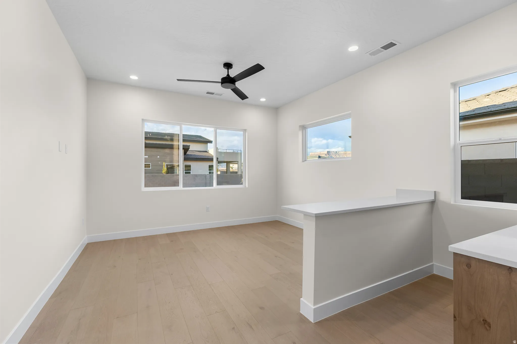 Unfurnished room with light wood-type flooring, a ceiling fan, and recessed lighting