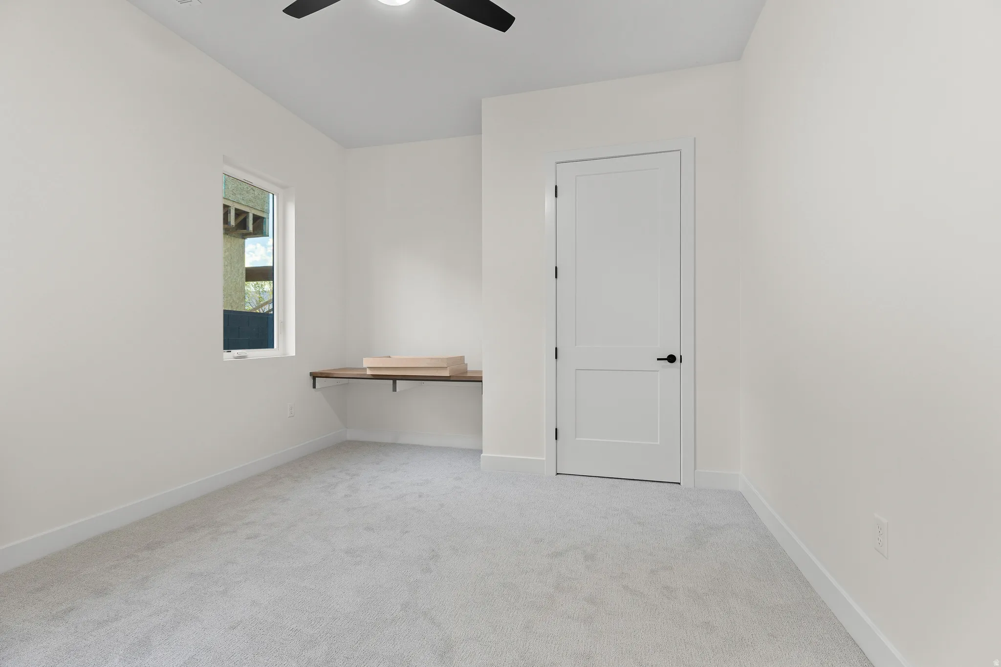 Unfurnished room with light carpet and a ceiling fan