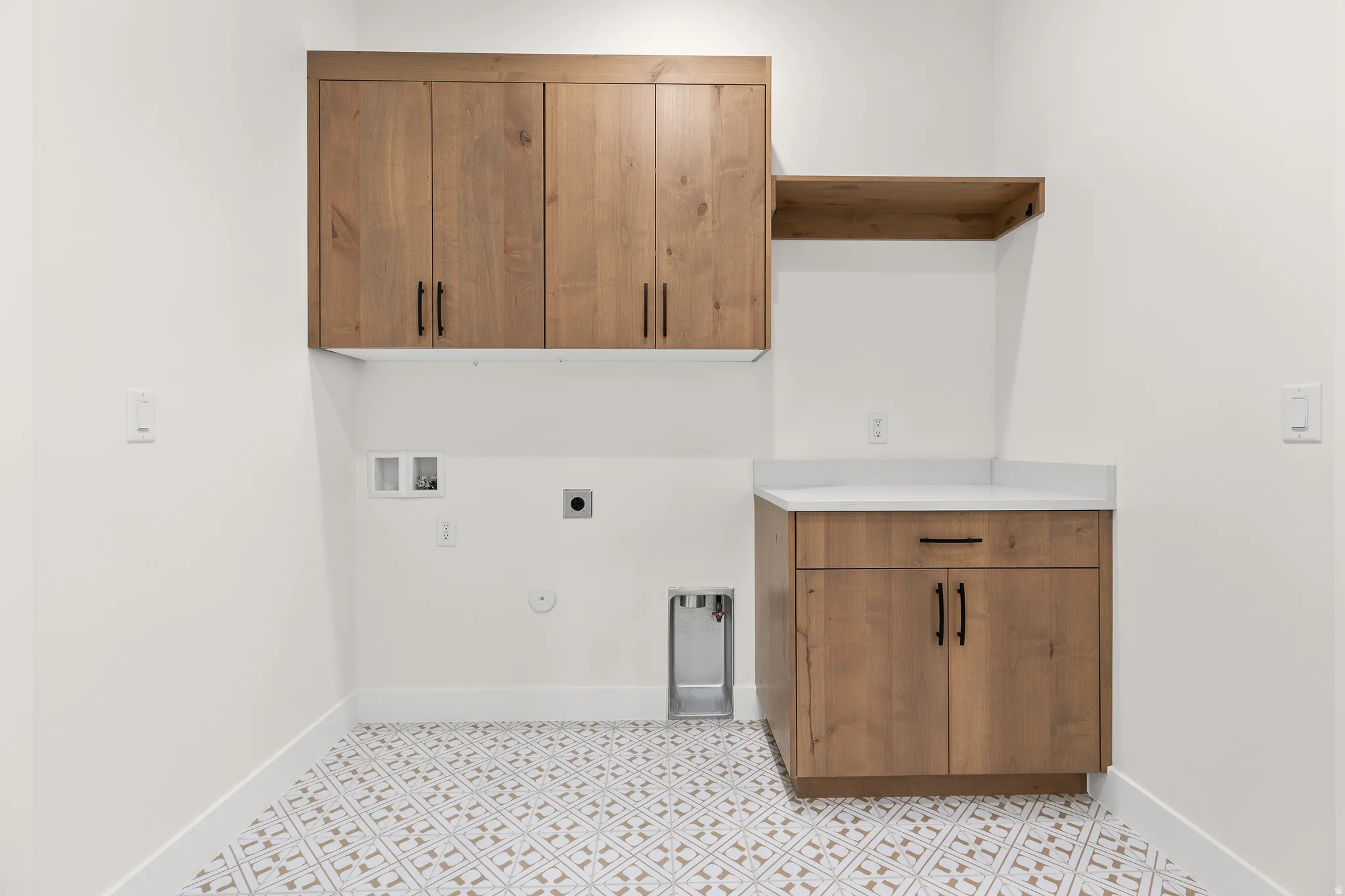 Laundry area with gas dryer hookup, hookup for a washing machine, electric dryer hookup, cabinet space, and light flooring
