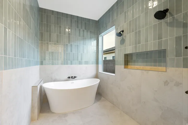 Full bath with tile walls, a freestanding bath, and a tile shower