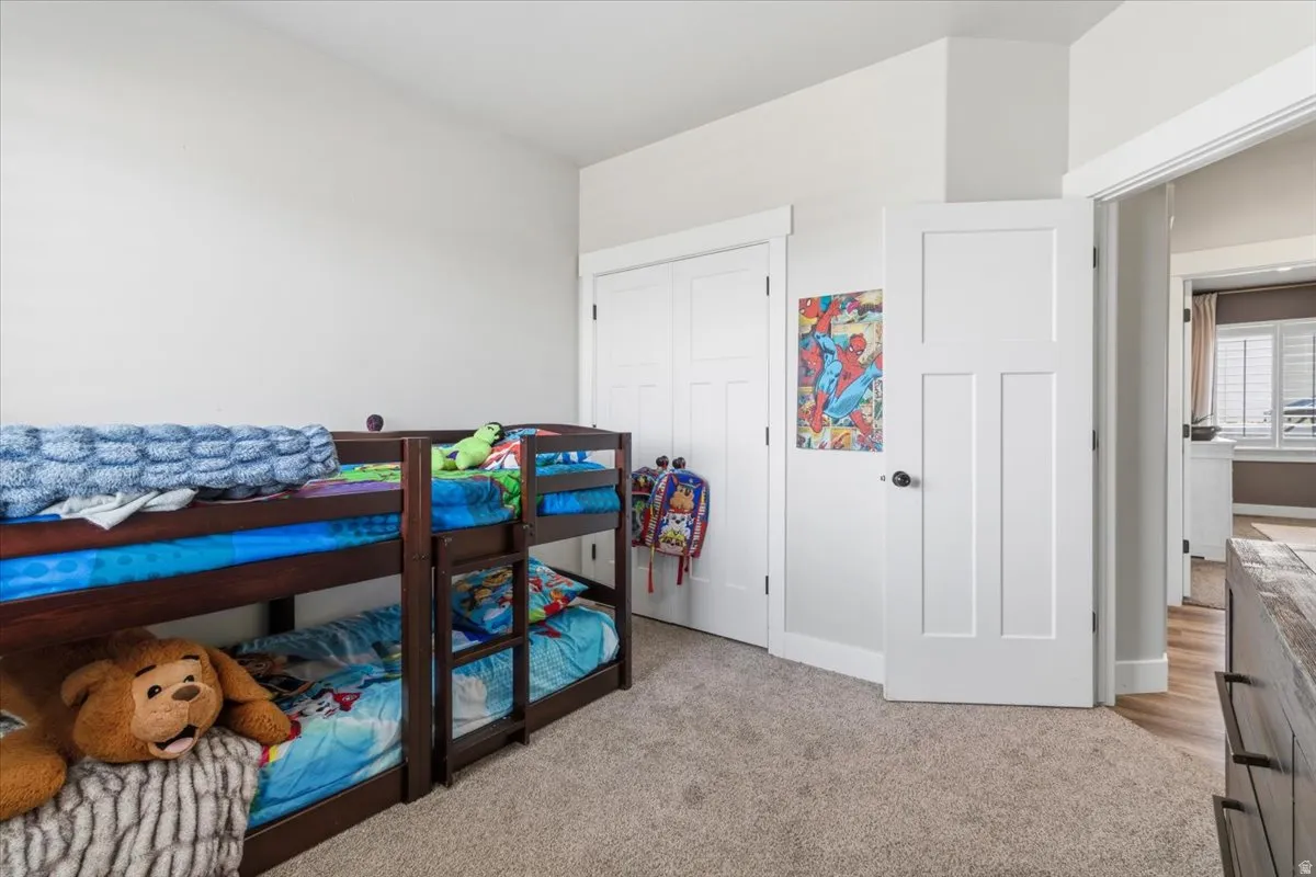 Bedroom featuring light carpet and a closet