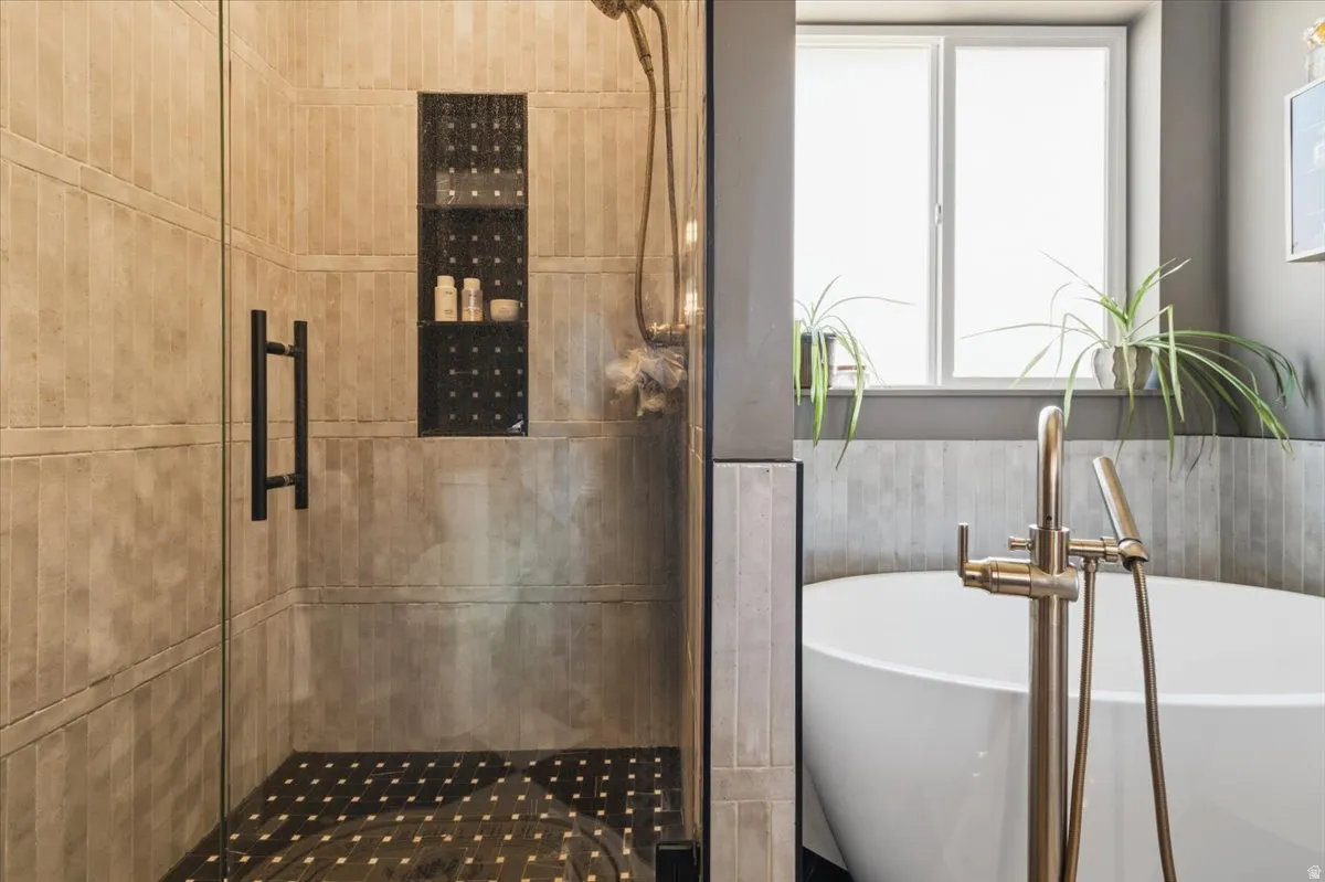 Full bath with a stall shower and a soaking tub