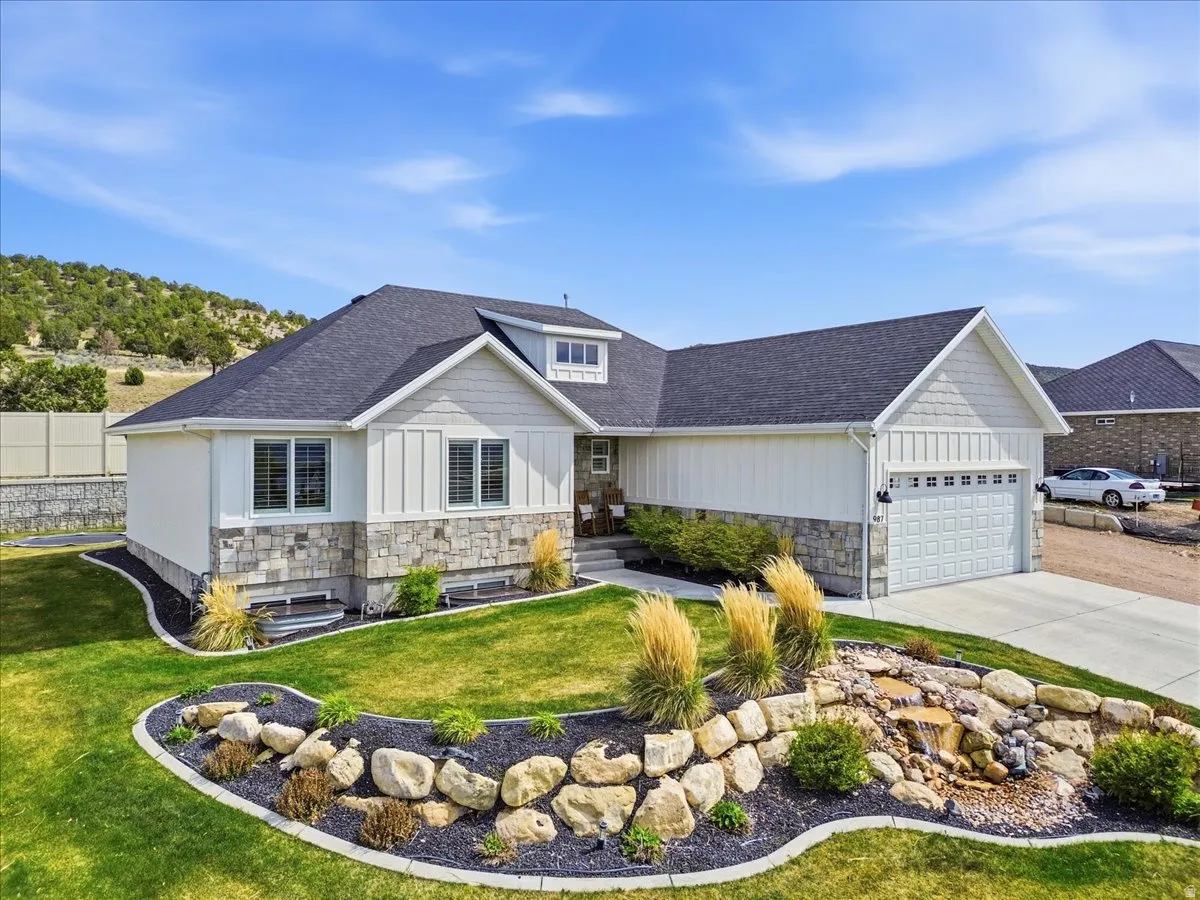 View of front of house featuring stone siding, board and batten siding, and roof with shingles