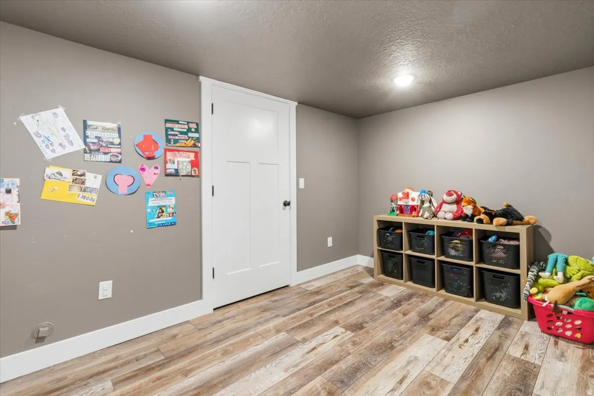 Rec room with a textured ceiling and light wood finished floors