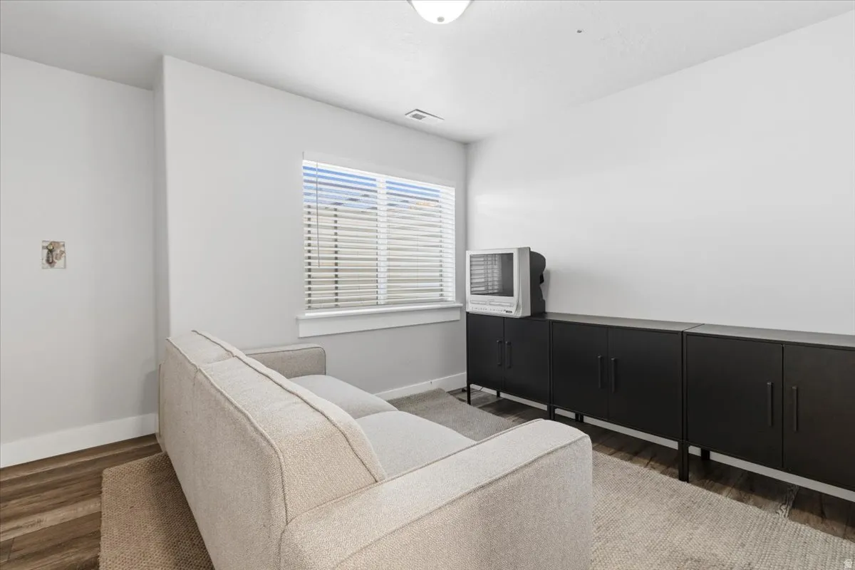 Living area featuring dark wood finished floors and baseboards