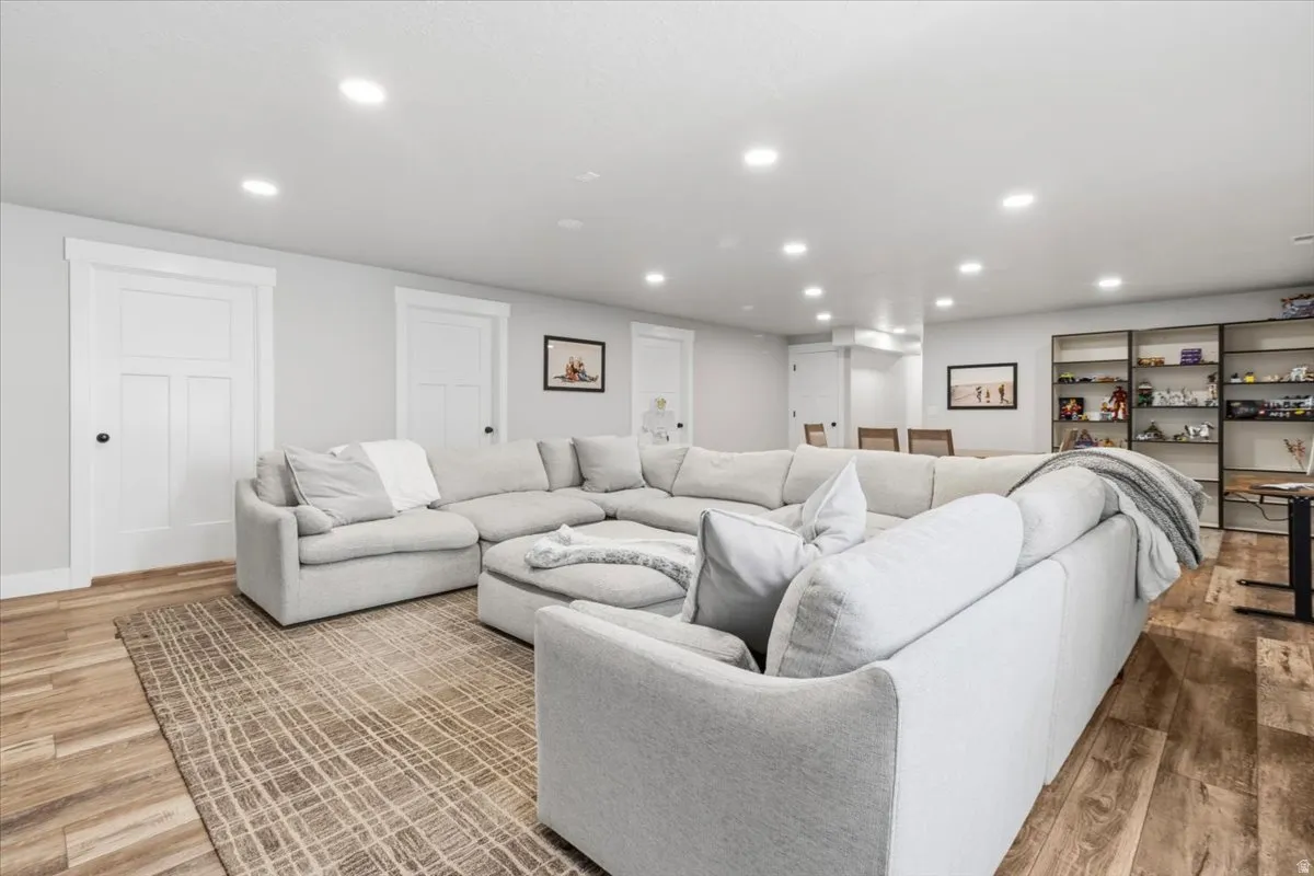Living room with light wood-style flooring and recessed lighting