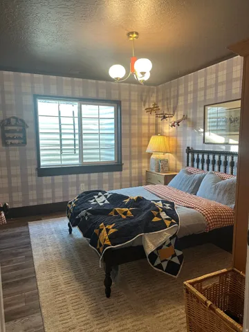 Window with white blinds, dark wood-finish flooring, and a ceiling-mounted light fixture