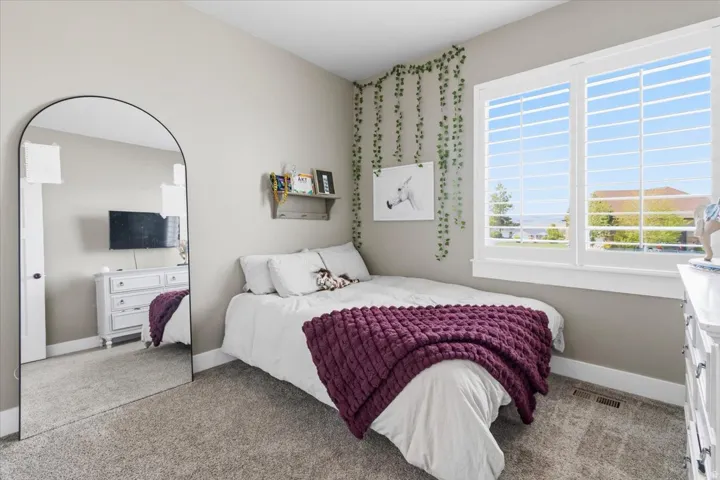 Bedroom featuring light colored carpet