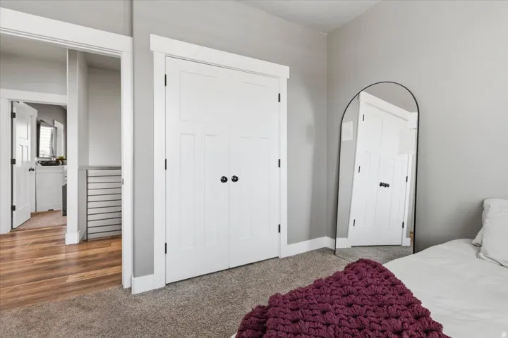 Carpeted bedroom featuring a closet and baseboards