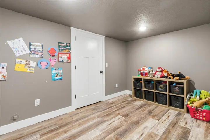 Rec room with a textured ceiling and light wood finished floors