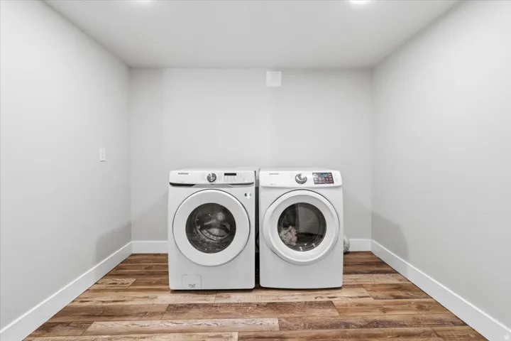 Laundry area with light wood-type flooring and washing machine and dryer