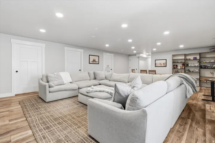 Living room with light wood-style flooring and recessed lighting