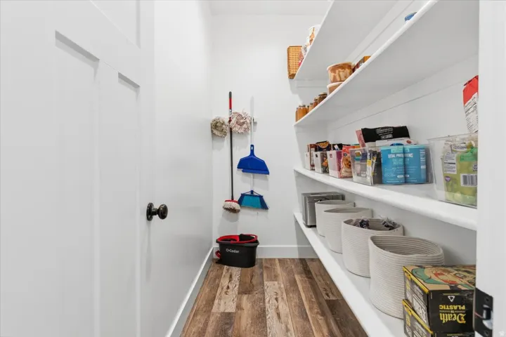 Laundry area featuring dark wood-type flooring and baseboards