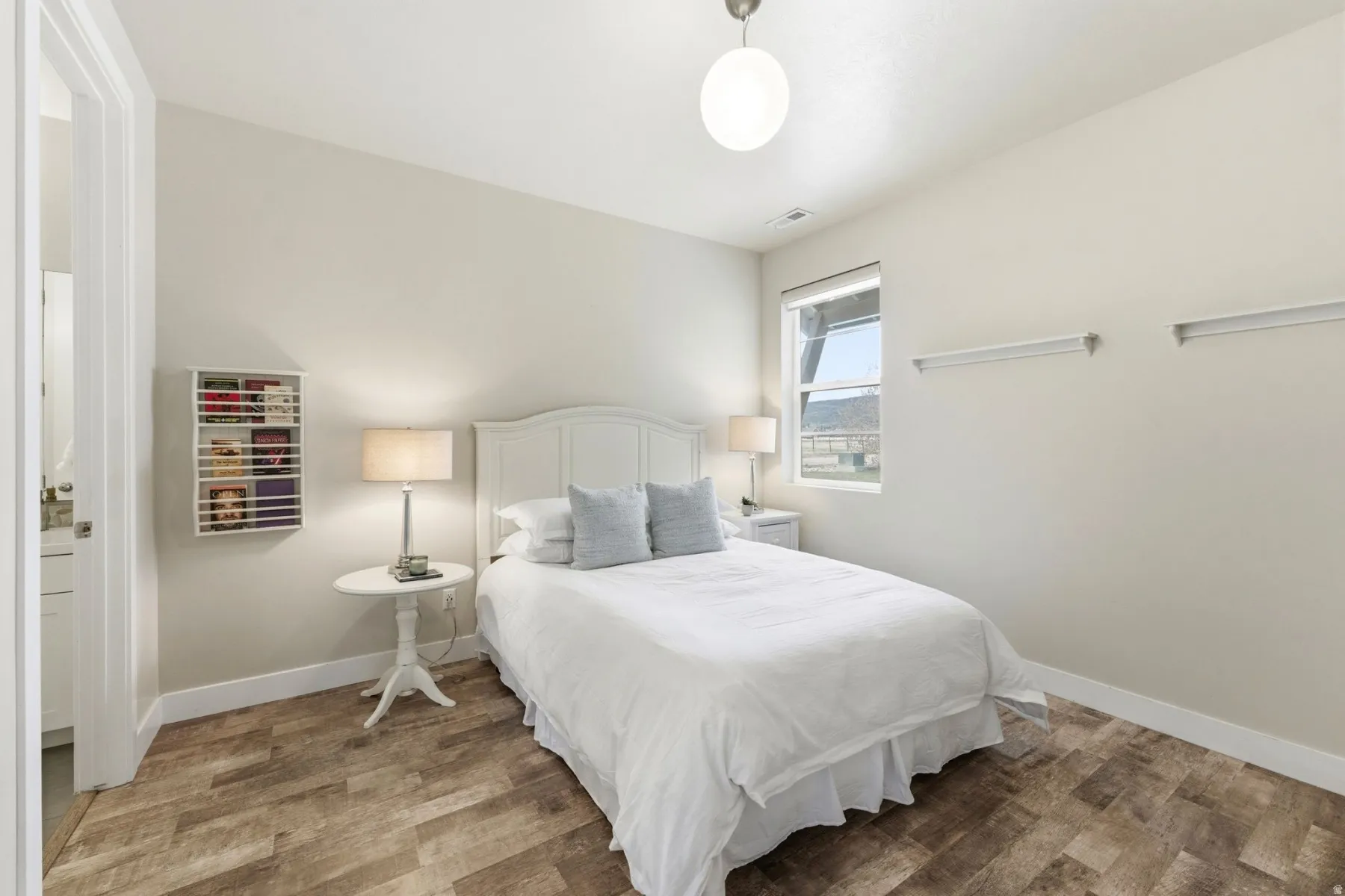 Bedroom with wood finished floors and baseboards