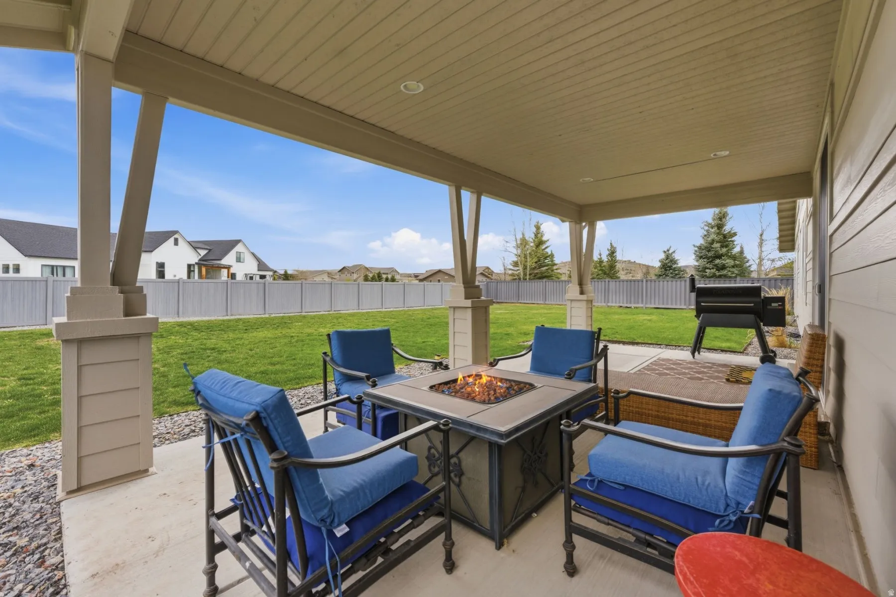 Fenced backyard featuring a patio, a residential view, and a fire pit
