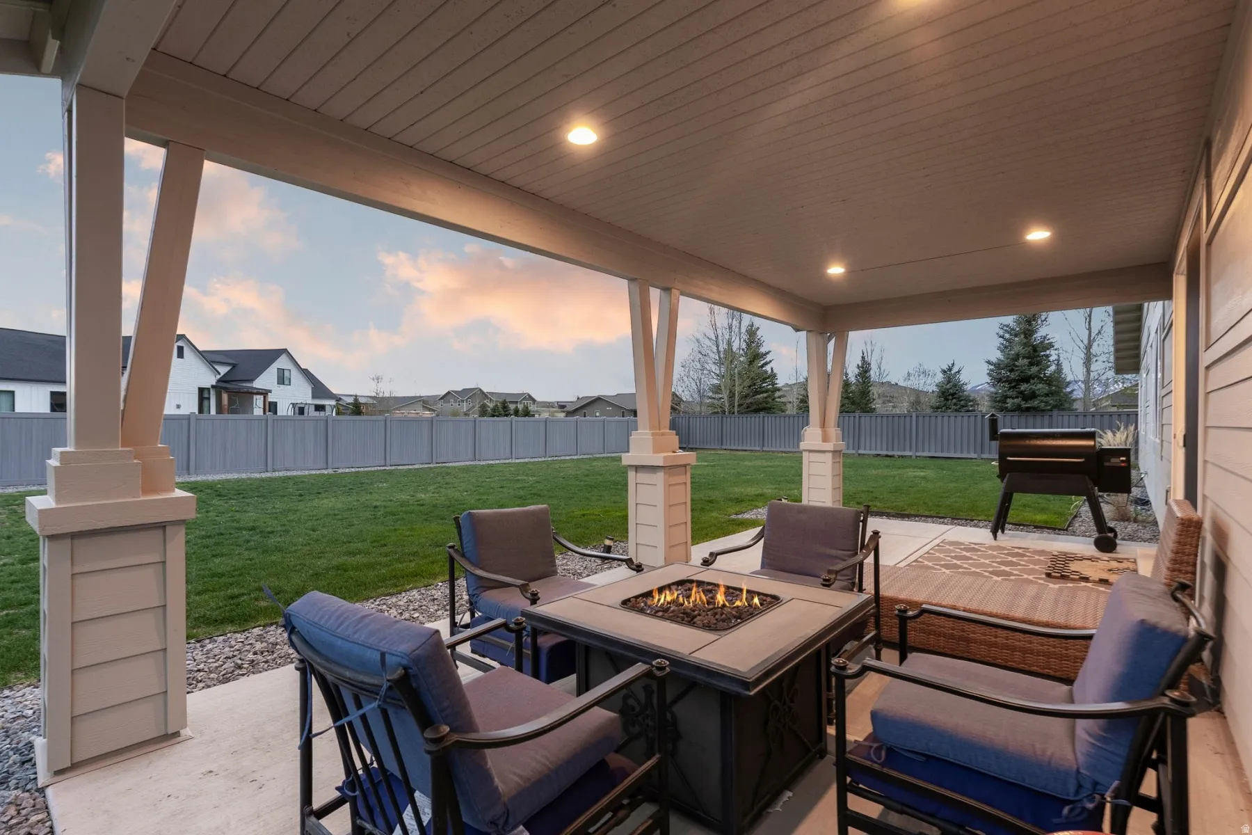 Fenced backyard featuring a patio area, an outdoor fire pit, and a residential view