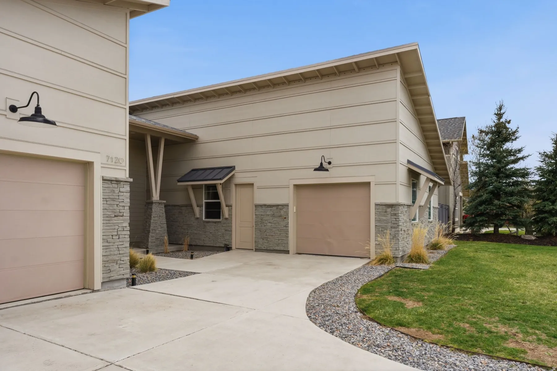 View of property exterior featuring a garage, concrete driveway, brick siding, and a lawn
