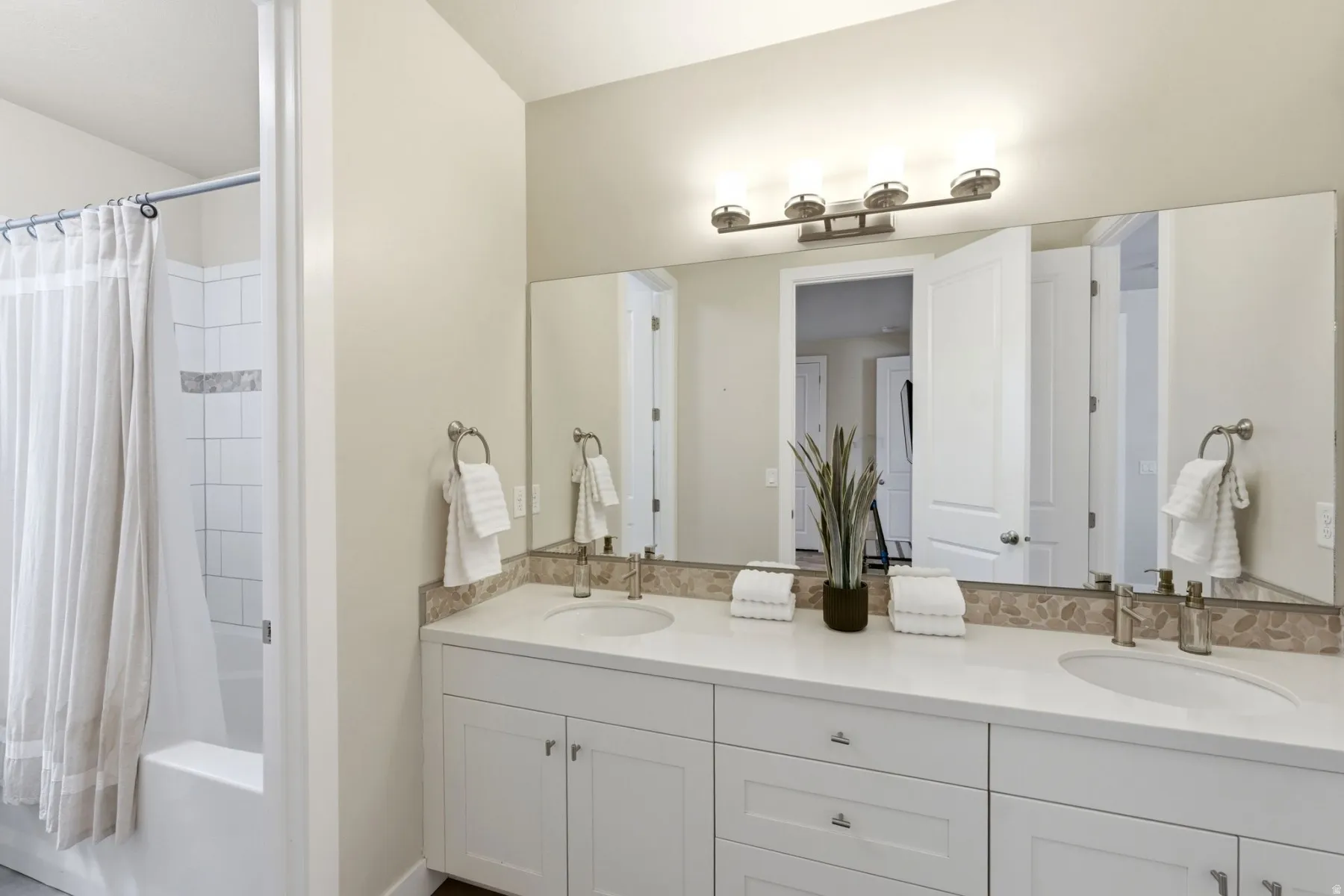 Full bath with double vanity and shower / tub combo
