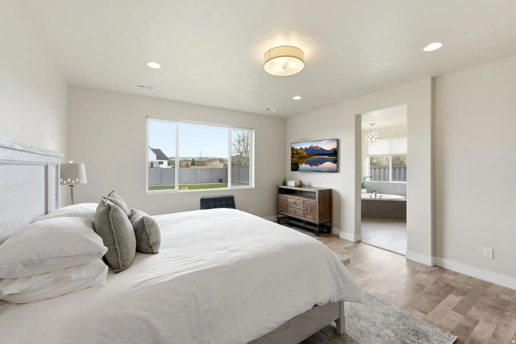 Bedroom featuring light wood-style flooring, recessed lighting, and ensuite bathroom