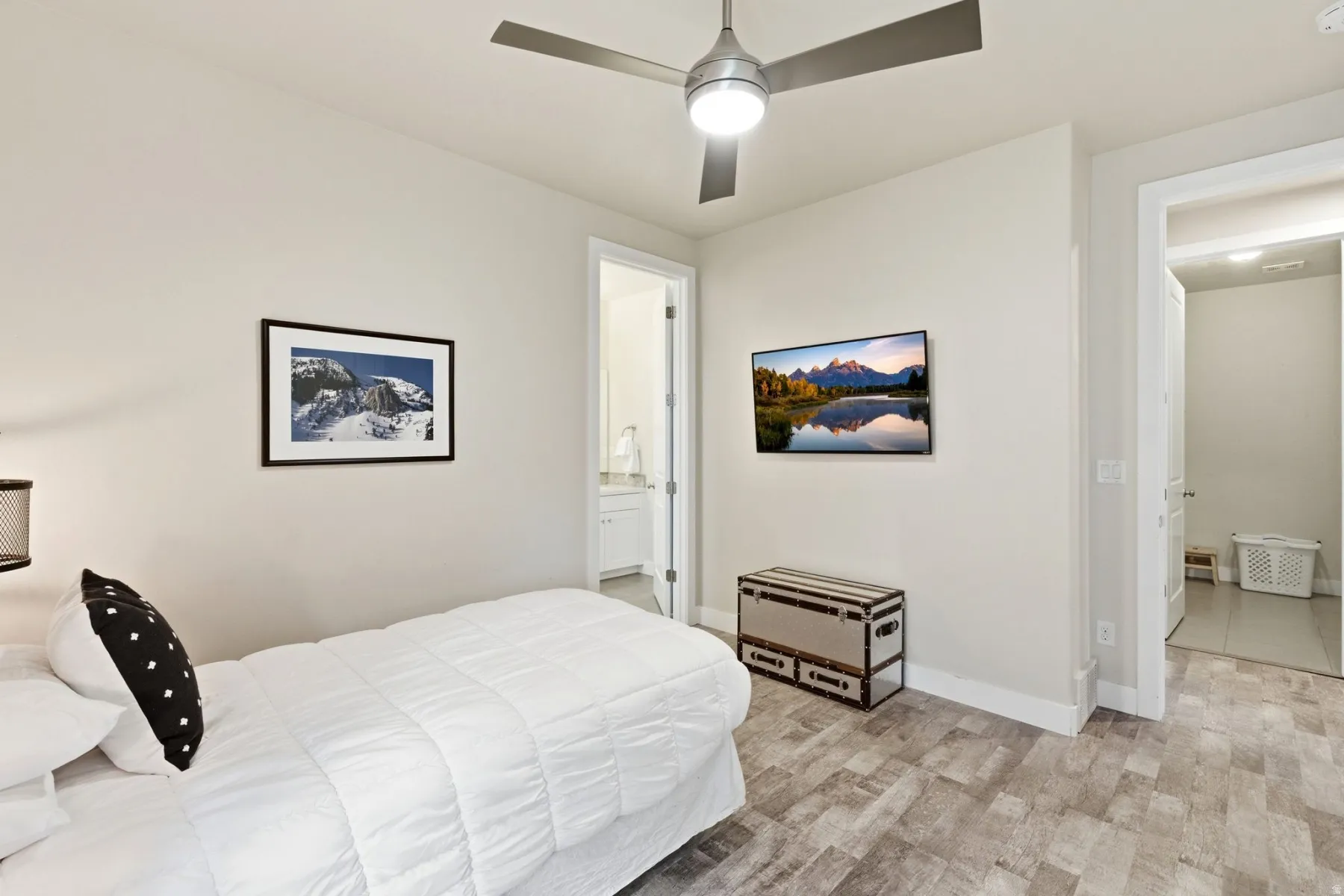 Bedroom with connected bathroom, ceiling fan, and light wood finished floors